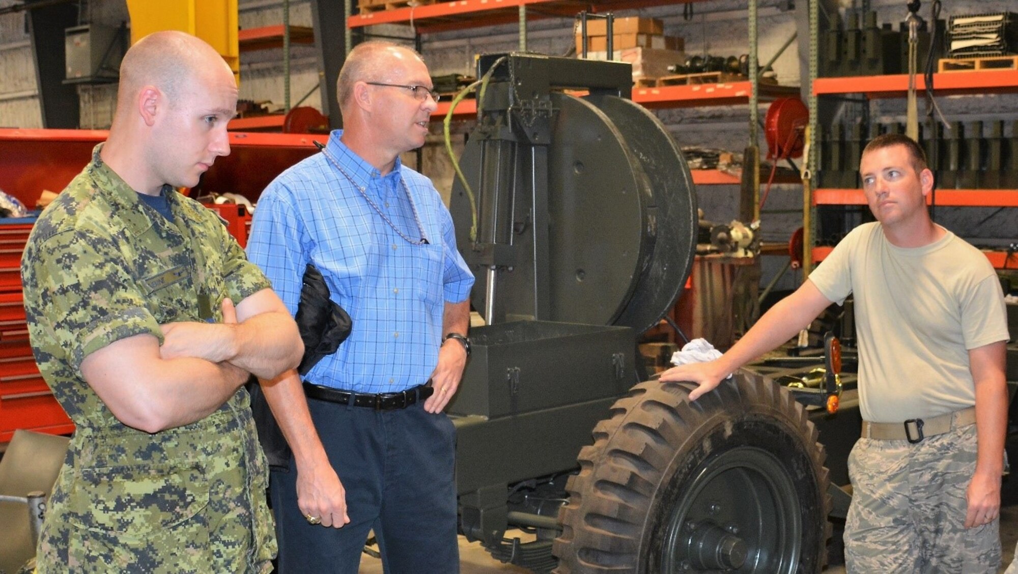At left, Capt. Nicholas Sabine, Royal Canadian Air Force, 1 Canadian Air Division, A4 Construction Engineering, got an up close look at the U.S. Air Force Aircraft Arresting System, or AAS, during a recent visit to the Air Force Civil Engineer Center at Tyndall AFB, Florida.  Dr. Barry Mines, AFCEC Operations Directorate subject matter expert for the AAS and Staff Sgt. Ryan Moody, industrial power production craftsman were on hand to answer questions and provide an overview of the system.