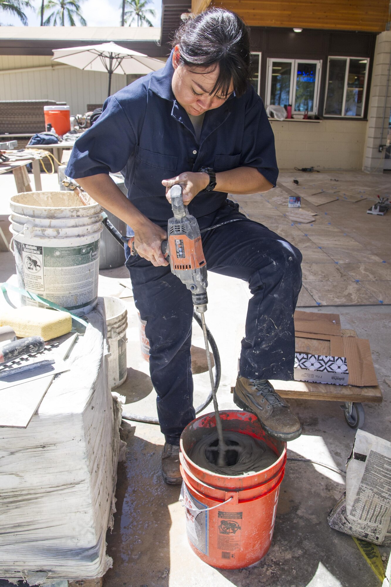 U.S. Air Force Senior Airman Veleesa Conley, of Wahiawa, Hawaii, a structural engineer with the Air Force Reserve’s 624th Civil Engineer Squadron, mixes mortar to install tile for the recreation center's 4,500-square-foot lanai at Bellows Air Force Station, Waimanalo, Aug. 25, 2017.