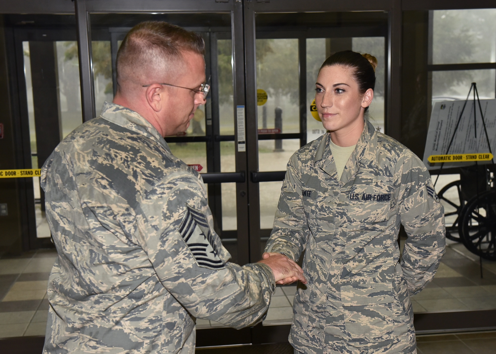 U.S. Air Force Chief Master Sgt. David W. Wade, 9th Air Force command chief at Shaw Air Force Base, S.C., coins Senior Airman Lauren DiFante, 325th Medical Support Squadron radiology diagnostic imaging technologist, during a base visit to Tyndall Air Force Base, Fla., Aug. 29, 2017. Wade spent time at different units talking with Airmen and highlighting their place in the profession of arms and how their efforts affect the Tyndall mission. (U.S. Air Force photo by Senior Airman Sergio A. Gamboa/Released)