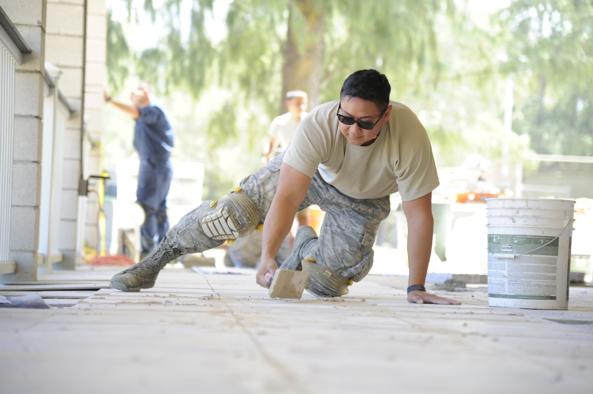 U.S. Air Force Senior Airman Ryan Ang, of Ewa Beach, Hawaii, a structural engineer with the Air Force Reserve’s 624th Civil Engineer Squadron, applies tile grout for the recreation center's 4,500-square-foot lanai at Bellows Air Force Station, Waimanalo, Hawaii, Aug. 25, 2017.