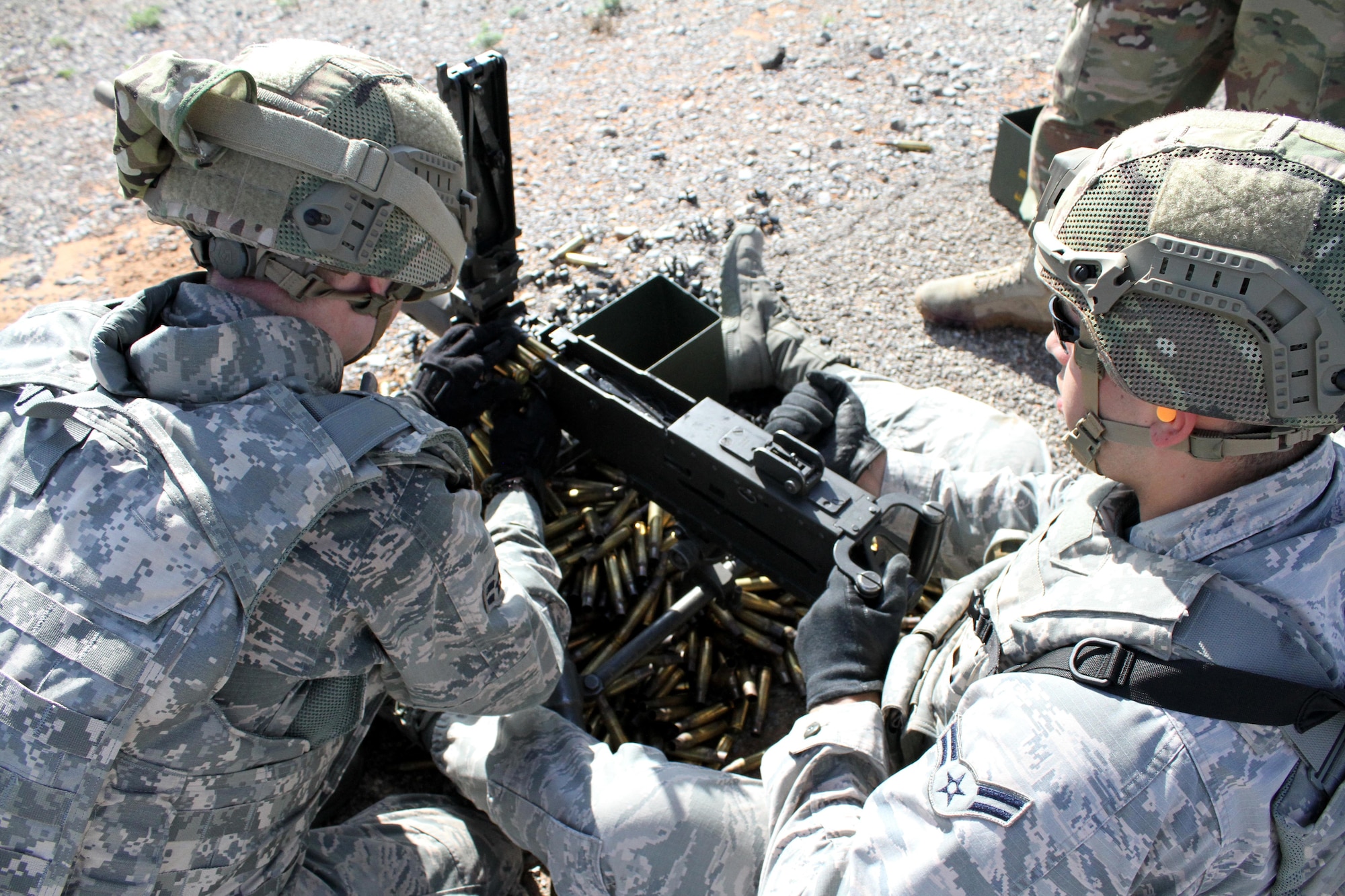 Assistant gunner Airman 1st Class Johnathan Gomez feeds ammunition for Airman 1st Class Cameren Miller during heavy weapons firing on Fort Bliss' Range 39 July 26, 2017.