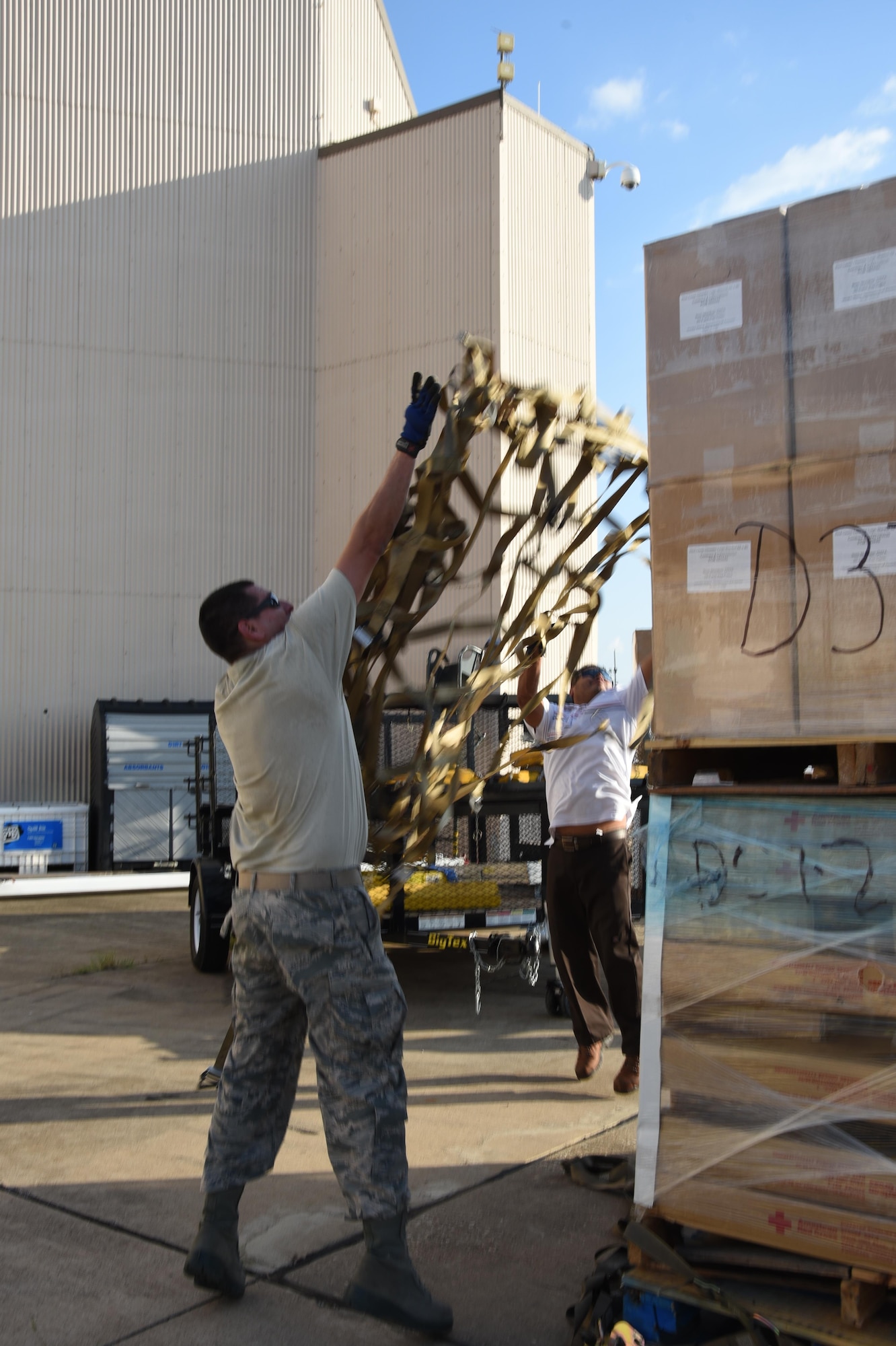 Air Force Tech. Sgt. Lucas Ortega, 73rd Aerial Port Squadron cargo supervisor, and Mr. Jose Guajardo, 301st Mission Support Group emergency management, toss webbing on a pallet to secure American Red Cross supplies before their transport August 29, 2017, at Naval Air Station Fort Worth Joint Reserve Base, Texas, in support of Hurricane Harvey relief efforts. There were 90,000 lbs. of supplies, included blankets and cots, sent as part of the Defense Support of Civil Authority. Department of Defense provides medium and heavy lift rotary wing assets, along with ground transportation, to move personnel, commodities and equipment within Texas. (U.S. Air Force photo by Ms. Julie Briden-Garcia)