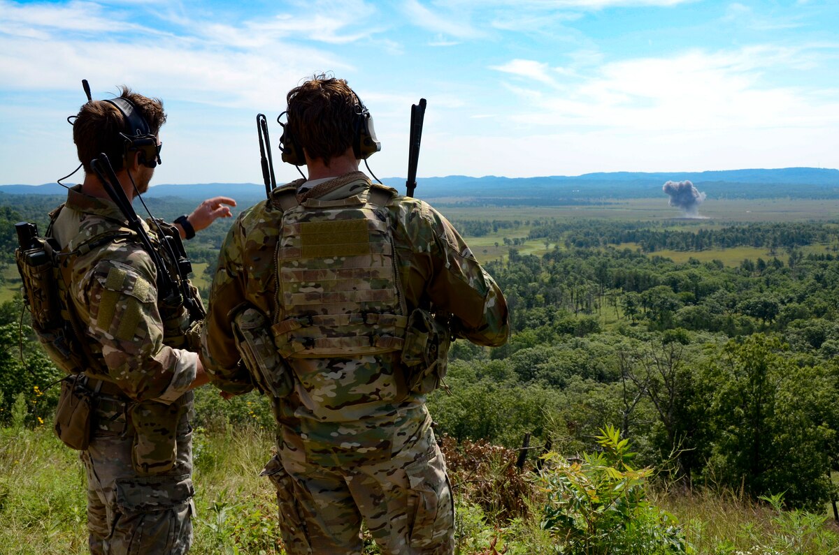 Tech. Sgt. Matt Lickel and Staff Sgt. Jackie Greathouse, U.S. Air Force Joint Terminal Attack Controllers (JTACs), watch as a Mark-82 high explosive bomb dropped by a 175th Fighter Squadron F-16 hits its target at the Fort McCoy, WI, live fire range Aug. 9, 2017.