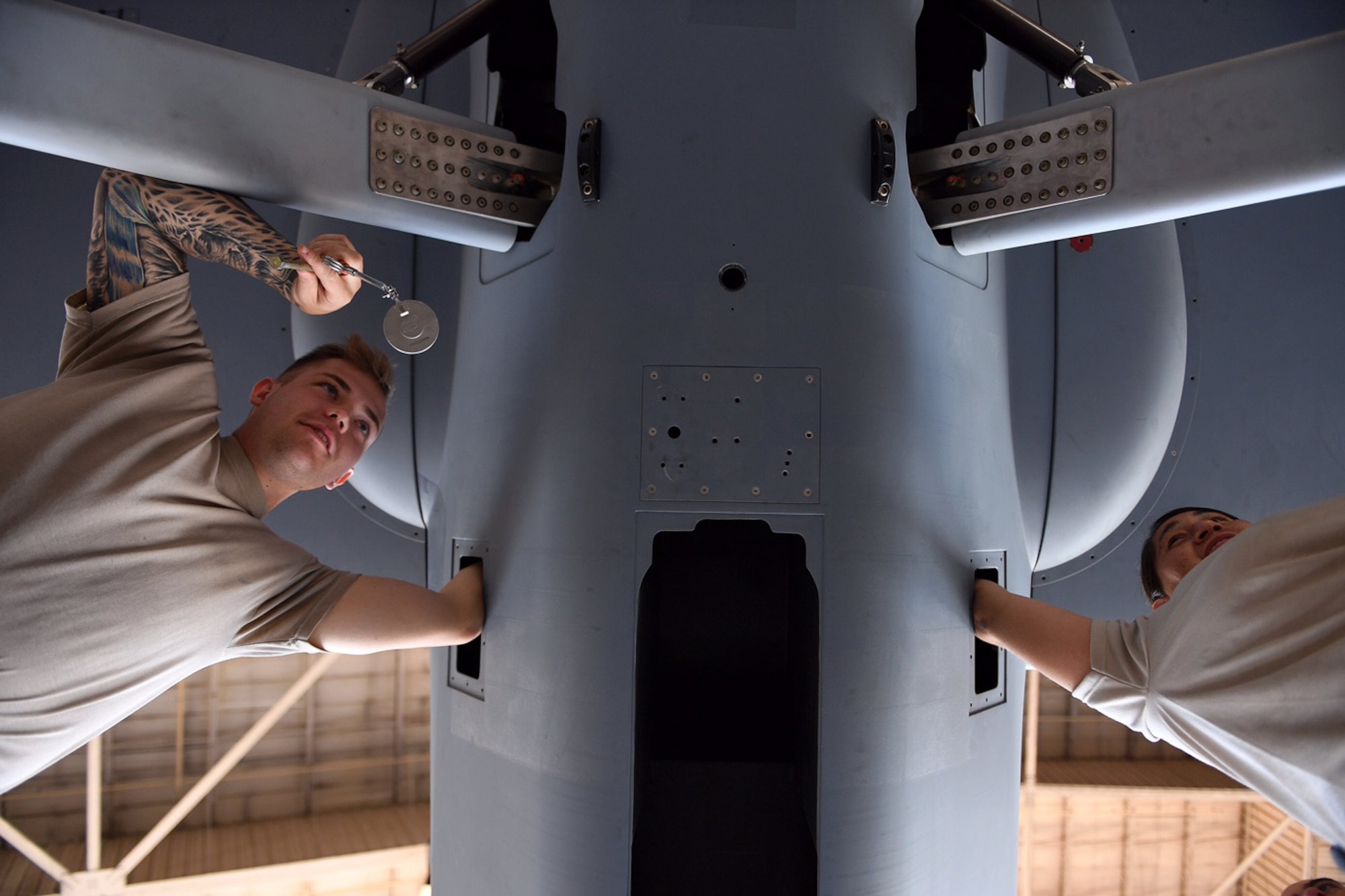 Airman 1st Class Conner and Staff Sgt. Nikki, both crew chiefs assigned to the 432nd Maintenance Group, work to assemble the MQ-9 Reaper model August 24, 2017, at Dover Air Force Base, Del., in preparation for the 2017 Thunder Over Dover Open House.