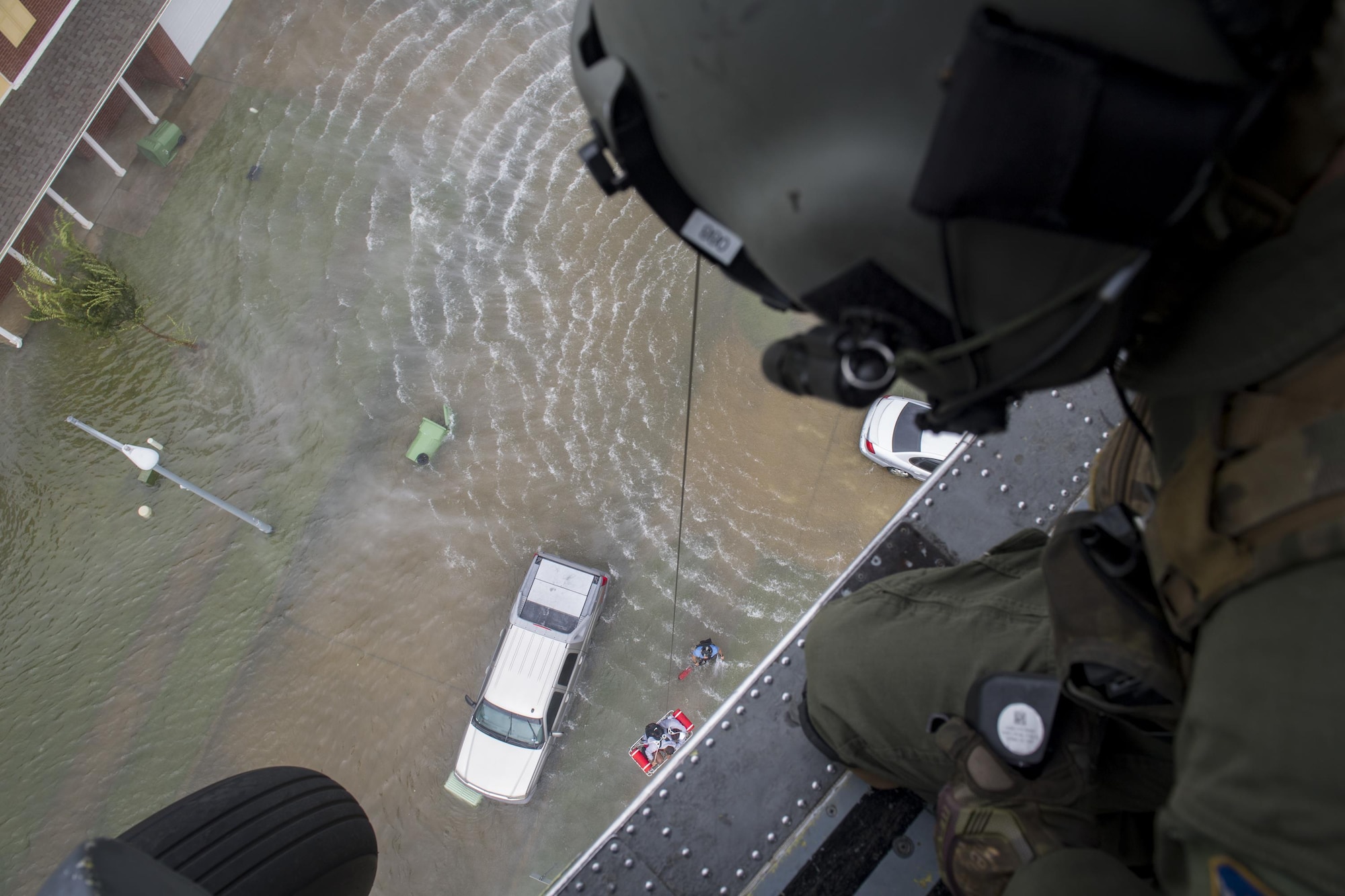 A special missions aviator from the 41st Rescue Squadron, watches as he raises a basket with an evacuee in it, Aug. 30, 2017, in the Houston, Texas area.