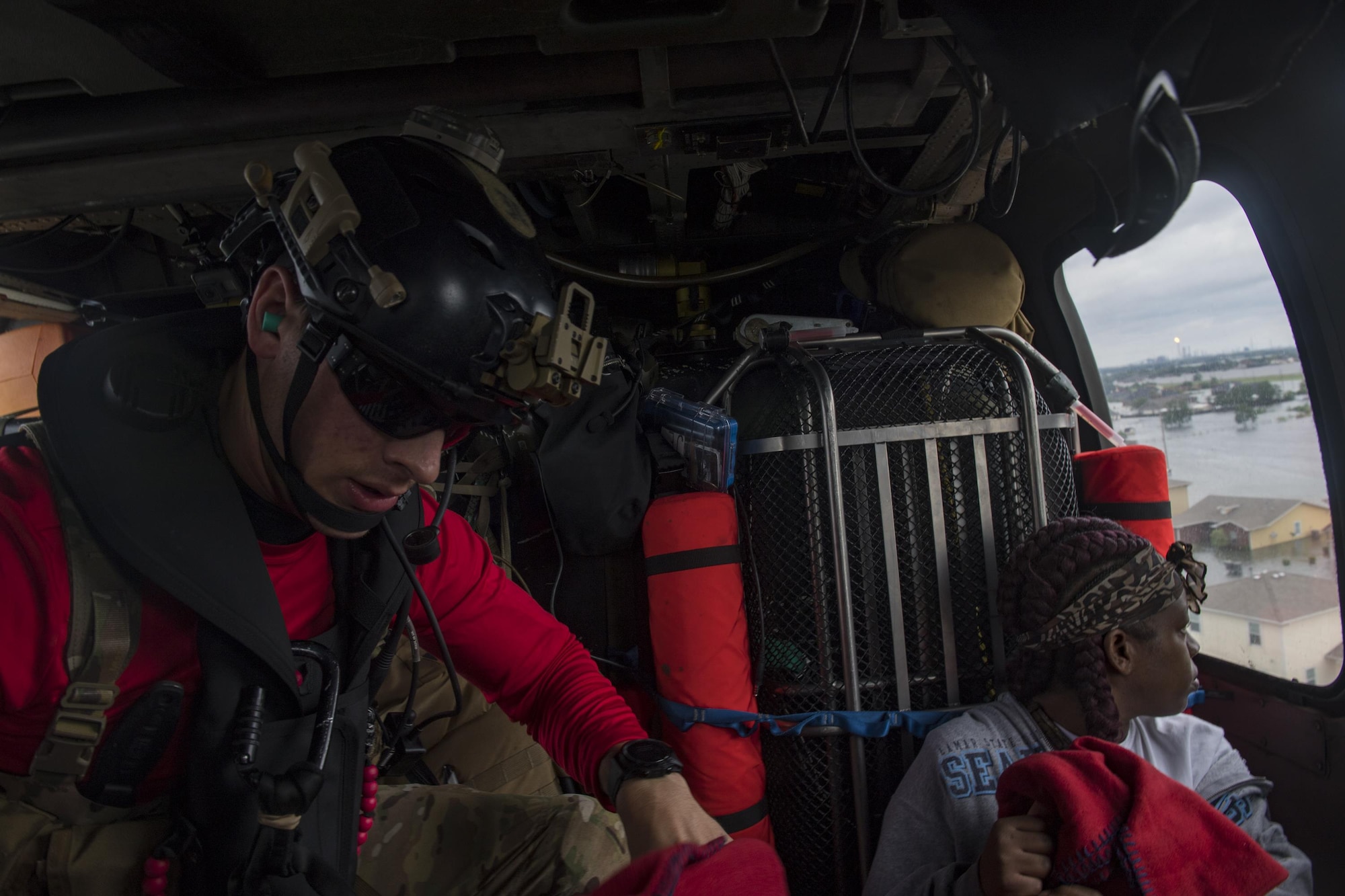 A pararescueman from the 38th Rescue Squadron reaches for more blankets for evacuees, Aug. 30, 2017, over the Houston, Texas area.