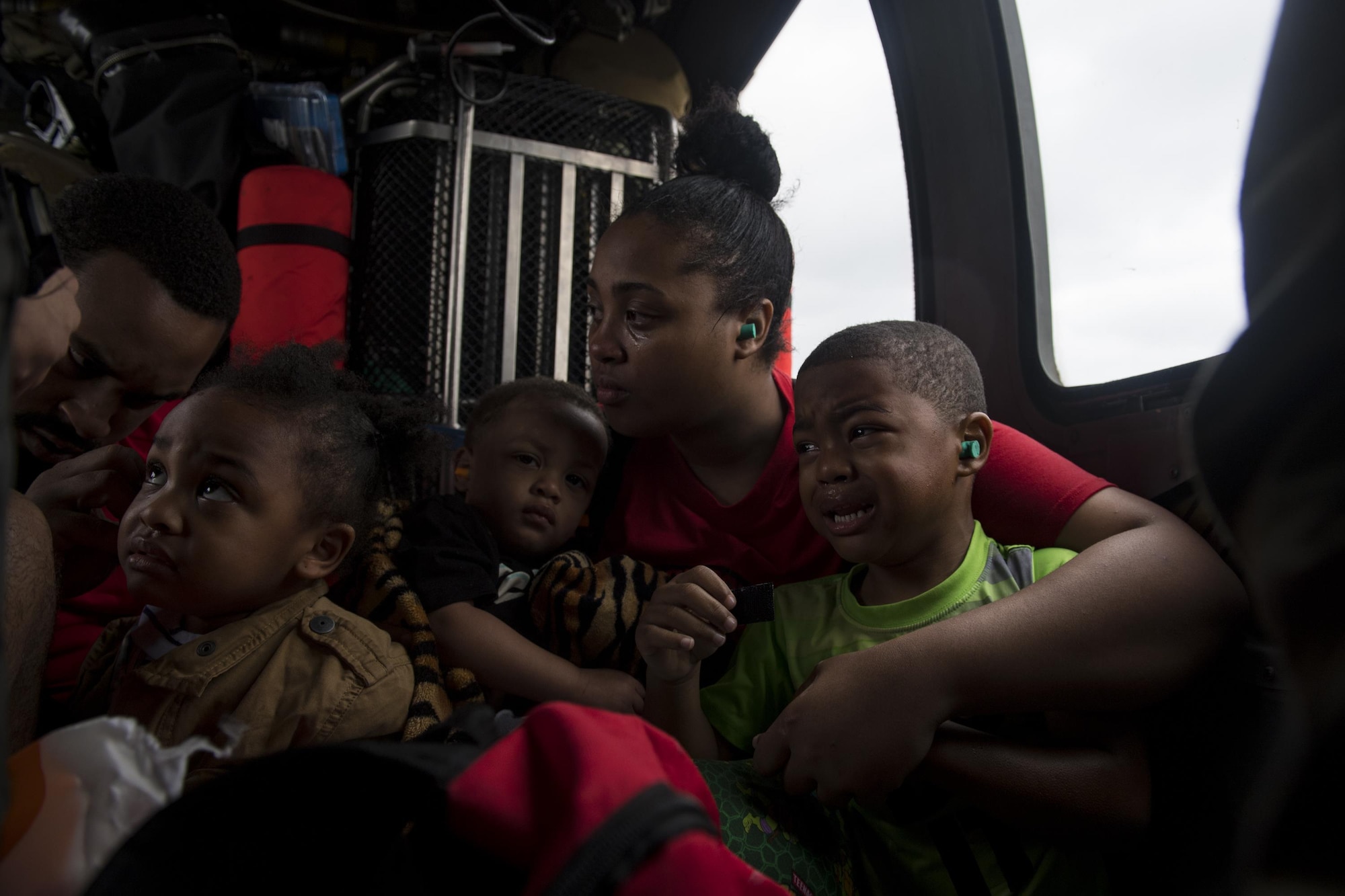 A family of evacuees wait for the rest of their family members onboard an HH-60G Pave Hawk, assigned to the 41st Rescue Squadron, Aug. 30, 2017, over a residence in the Houston, Texas area.