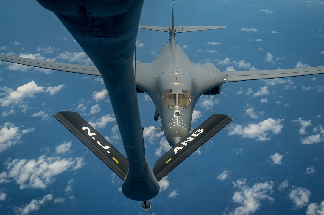 An aircraft refuels another aircraft in midair.