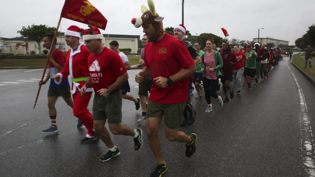 Marines and Sailors with Medical Logistics Company, 3rd Supply Battalion, Combat Logistics Regiment 35, run across base during the 7th Annual Jingle Bell Run hosted by Marine Corps Community Services at Camp Kinser, Okinawa, Japan Dec. 1, 2017. The event featured a costumed fun run, Christmas caroling, games and prizes for Marines and Sailors, who attended to celebrate the holiday season.