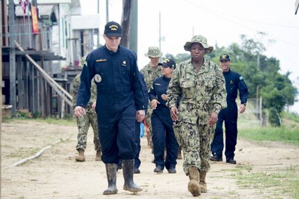 Medical personnel talk while walking.