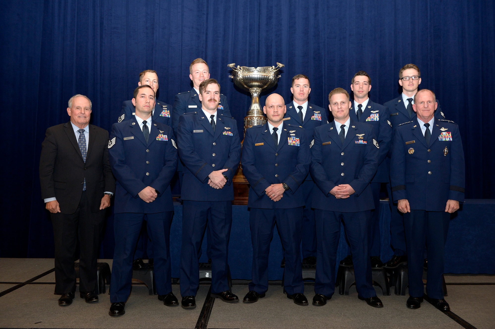Members of the AC-130U Gunship aircrew known as "Spooky 43" Air Force Vice Chief of Staff Gen. Stephen W. Wilson and Lt. Gen. (Ret.) Stephen Wood pose for a photo in front of the MacKay trophy Nov. 29, 2017, in Arlington, Va.  The aircrew received the trophy during an awards dinner. First awarded in 1912, the Mackay Trophy honors the most meritorious U.S. Air Force flight of the previous year. (U.S. Air Force photo by Staff Sgt. Rusty Frank)