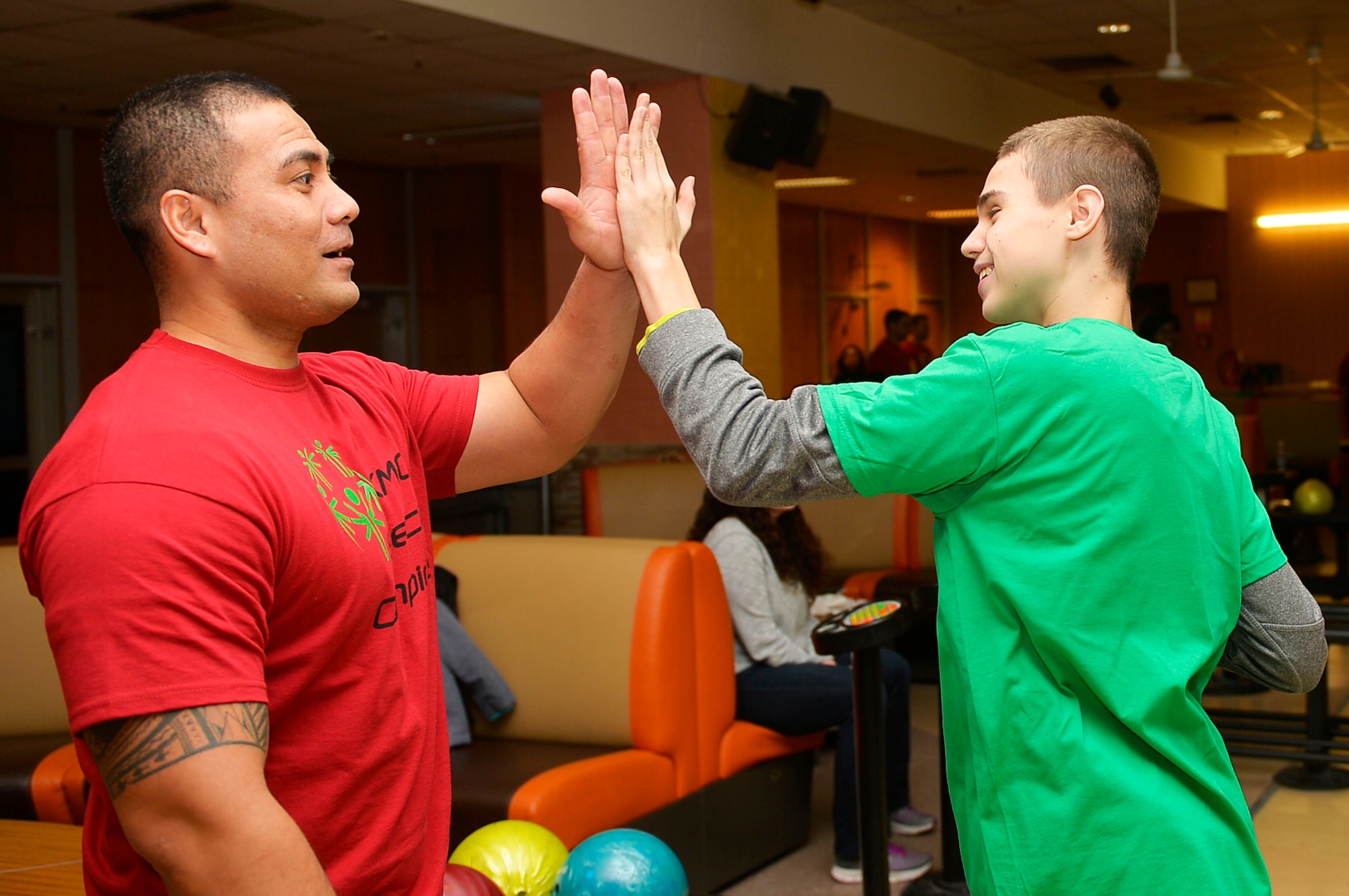 U.S. Army Sgt. 1st Class Rahim Fuiava, 773rd Civil Support Team information system analyst, congratulates a participant during the Kaiserslautern Military Community Winter Special Olympics on Vogelweh Special Military Complex, Germany, Dec. 1, 2017. The KMC Special Olympics occurs every spring and winter, and involves students from both German and American schools. (U.S. Air Force photo by Airman 1st Class Joshua Magbanua)