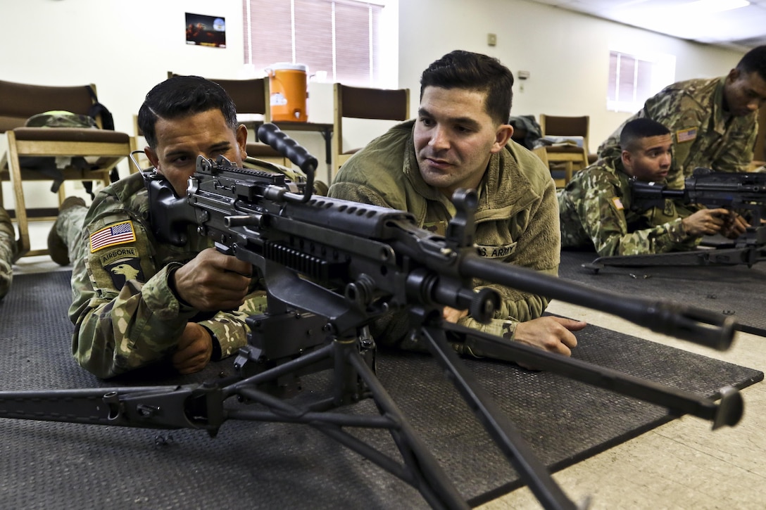 Army Reserve Sgt. Ruben Cardenas, indirect fire infantryman, practices target acquisition with an M249 light machine gun with Pfc. Luis Mong, a chemical, biological, radiological and nuclear specialist at Fort Hunter Liggett, Calif.