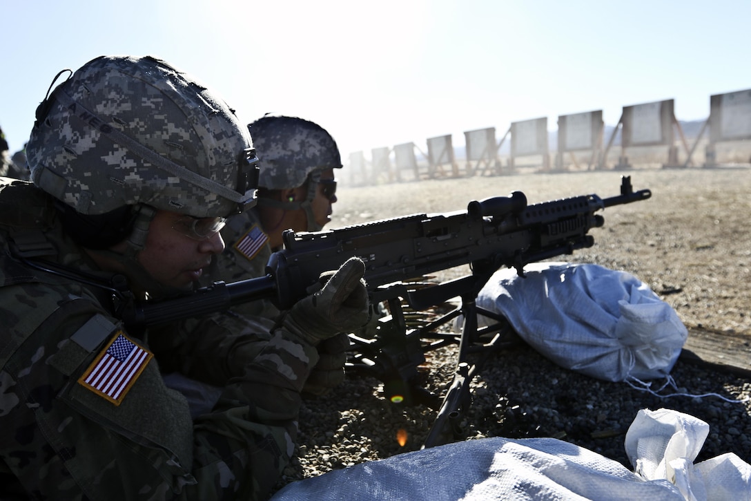 Army Reserve Spc. Andrew Torres pulls back the charging handle of an M240B machine gun while qualifying during Operation Cold Steel II, hosted by the 79th Theater Sustainment Command on Fort Hunter Liggett, Calif.