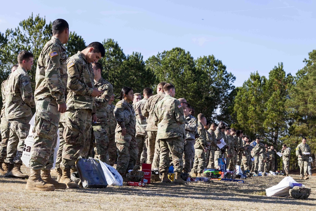 Soldiers wait to have their names placed on the flight manifest roster before donating toys for the 20th Annual Randy Oler Memorial Operation Toy Drop at Fort Bragg, N.C.