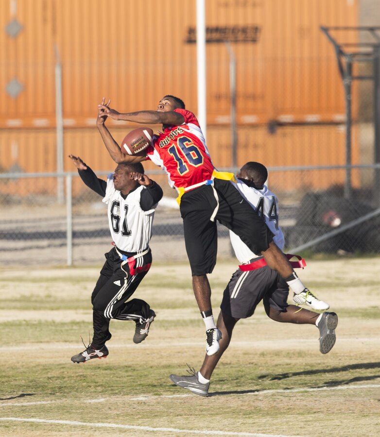 Lance Cpl. Jacob Brown (16), between two defenders, lets a potential touchdown slip through his arms, during the first Turkey Bowl held aboard Marine Corps Logistics Base Barstow Nov. 21. The Marine Reservists assigned to Fleet Support Division took the championship trophy.
