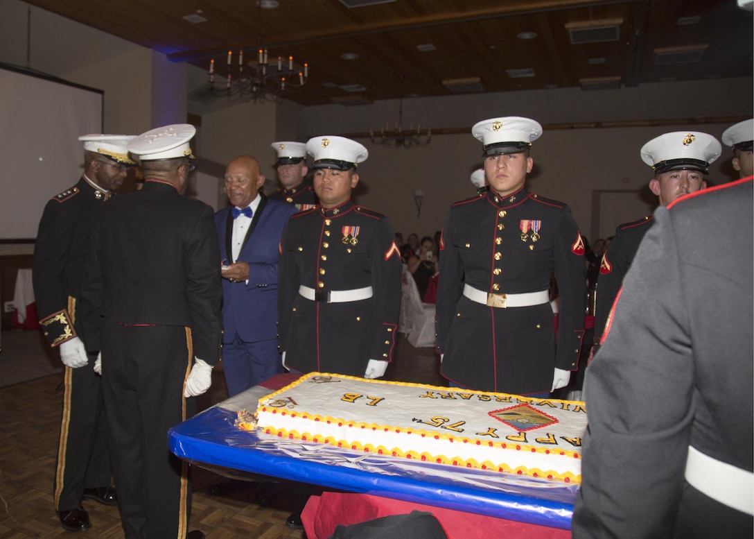 Lieutenant General Ronald Bailey, USMC Retired, and Colonel Sekou Karega, commanding officer, Marine Corps Logistics Base Barstow, serve the traditional first piece of birthday cake to the eldest Marine present, Sgt. Maj. Lonnie Long, USMC Retired, during the 242nd Marine Corps Birthday Ball ceremonies held at Big Bear Lodge, Big Bear, Calif., Nov. 18.