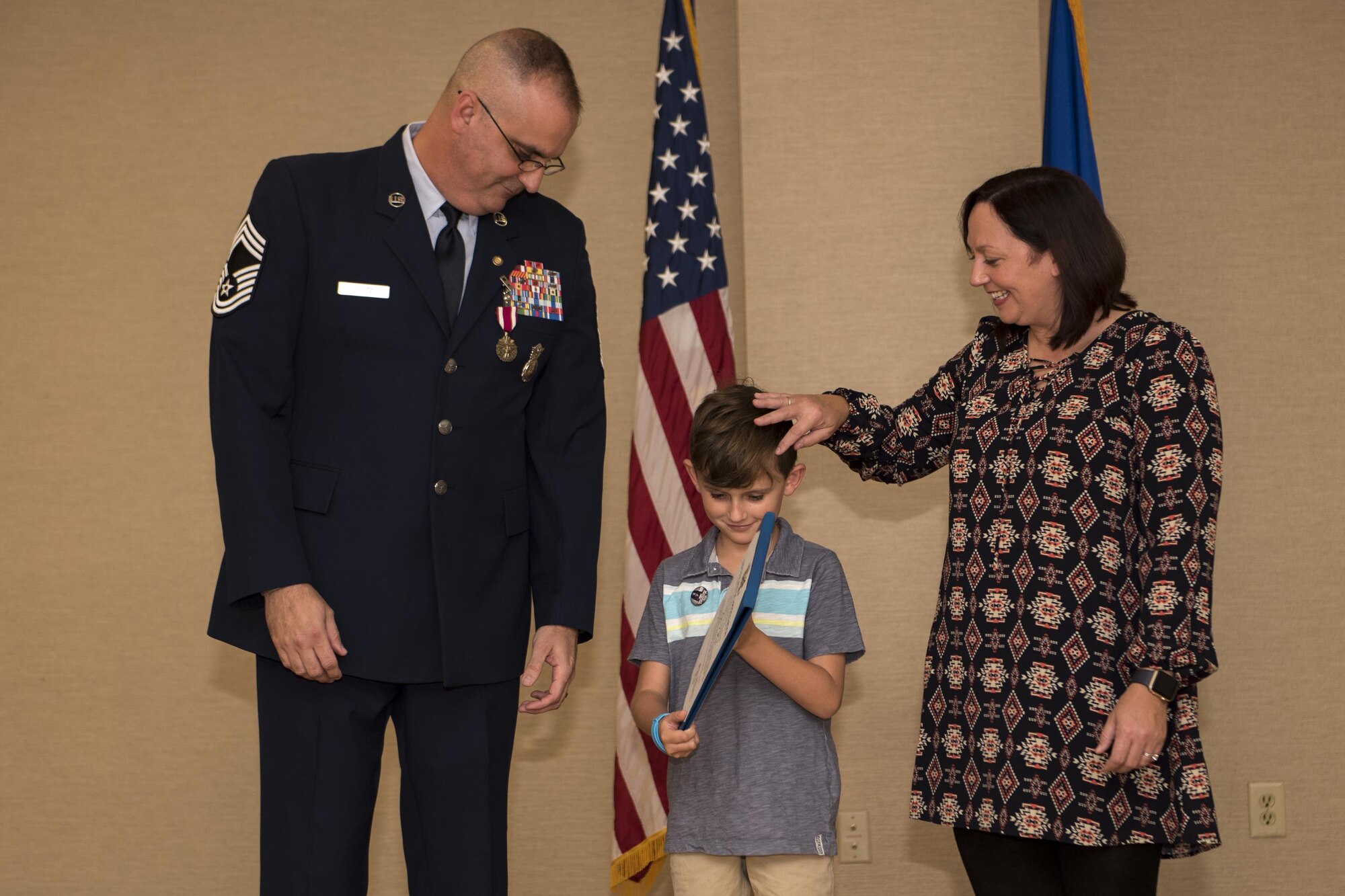 Chief Master Sgt. David Houtz, 823d Base Defense Squadron chief enlisted manager, and his wife, Beth, present their son, Logan, with an appreciation award, during Houtz’s retirement ceremony, Dec. 1, 2017, at Moody Air Force Base, Ga. Houtz enlisted in the Air Force on Oct. 6, 1991. During his 27-year career, he has held numerous leadership roles while supporting Operations Provide Promise, Southern Watch, Enduring Freedom, Iraqi Freedom and Inherent Resolve. (U.S. Air Force photo by Senior Airman Daniel Snider)