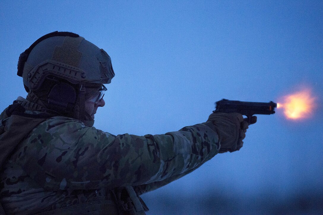 An airman fires a pistol.