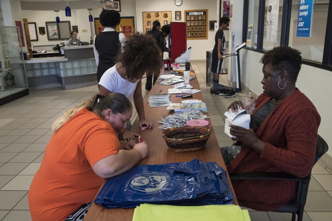 Attendees look at giveaways during the Airmen and Family Readiness Center’s (AFRC) ‘grand reopening’, Nov. 29, 2017, at Moody Air Force Base, Ga. The AFRC relocated to the Freedom 1 Fitness Center, but held the event as the grand finale to their month of the military family campaign and to showcase their new location to Moody. (U.S. Air Force photo by Senior Airman Janiqua P. Robinson)