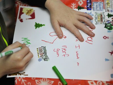 Mason, a child attending the holiday celebration, signs his letter to Santa at Joint Base Charleston – Weapons Station, S.C., Nov. 30, 2017.