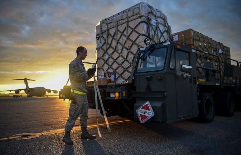Senior Airman Zachary Payne, 437th Aerial Port Squadron air cargo services technician, removes straps from a cargo load at Joint Base Charleston, S.C., Nov. 29, 2017.