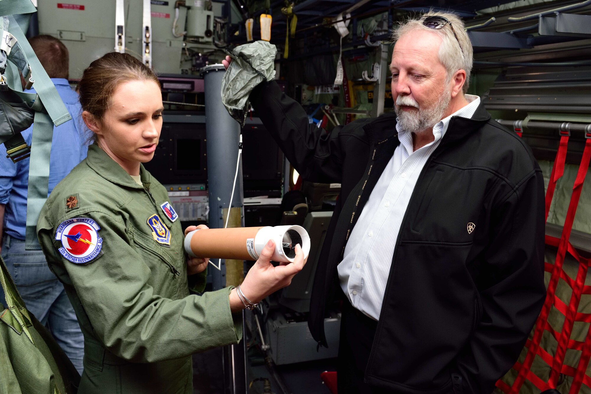 Maj. Ashley Lundry, 53rd Weather Reconnaissance Squadron aerial reconnaissance weather officer and chief scientific officer, shows a weather data-gathering instrument called a dropsonde to Dr. Fred “Marty” Ralph, Researcher and Director for the Center of Western Weather and Water Extremes, Scripps Institute of Oceanography, Nov. 29, 2017, at Brown Field Airport, San Diego, California. Hurricane Hunters met with Ralph and other Scripps scientists that day to discuss plans for participating in atmospheric river reconnaissance missions in early 2018. (U.S. Air Force photo by Tech. Sgt. Ryan Labadens)