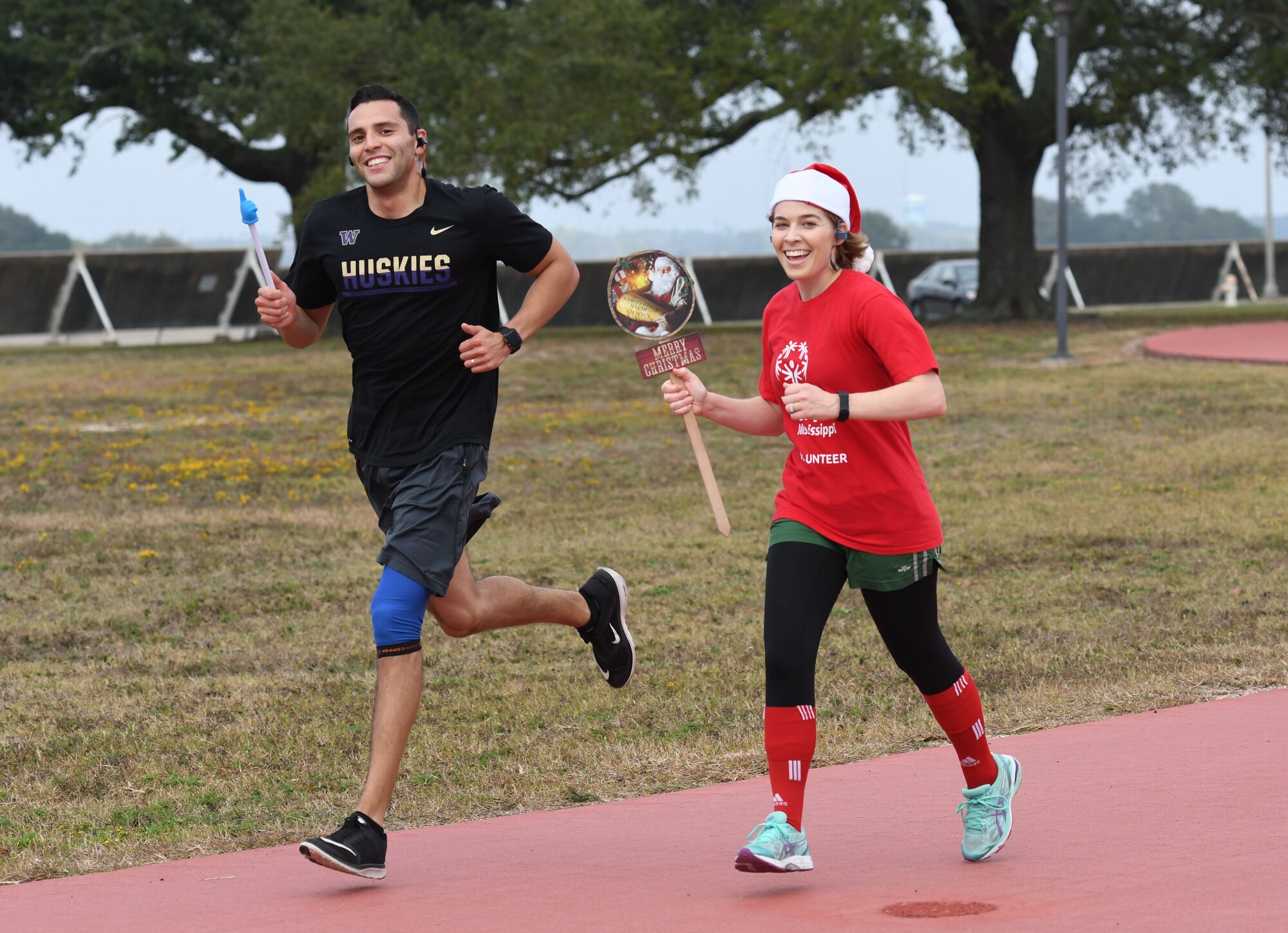 Capt. Arturo Urquieta, 333rd Training Squadron instructor, and Senior Airman Britanie Dollard, 81st Medical Operations Squadron cardiopulmonary technician, participate in the 8th annual Dragon Challenge at the triangle track Dec. 1, 2017, on Keesler Air Force Base, Mississippi. The base-wide event was held to bring together Airmen to promote physical training throughout the holidays. (U.S. Air Force photo by Kemberly Groue)