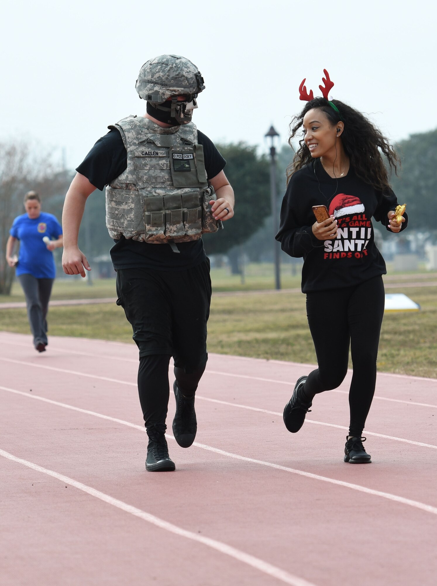 Staff Sgt. Drayton Callen, 81st Logistics Readiness Squadron deployment training NCO in charge, and Tech. Sgt. Ieashia McKenzie, 81st LRS quality assurance evaluator, participate in the 8th annual Dragon Challenge at the triangle track Dec. 1, 2017, on Keesler Air Force Base, Mississippi. The base-wide event was held to bring together Airmen to promote physical training throughout the holidays. (U.S. Air Force photo by Kemberly Groue)
