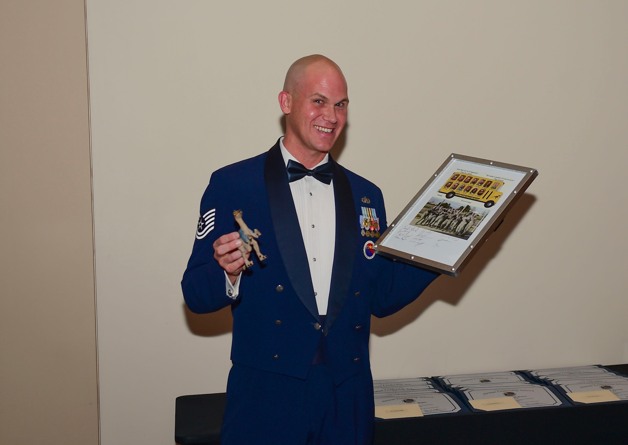 Tech Sgt. Travis Jackson, 460th Force Support Squadron Airman Leadership School raptor flight instructor, receives a gift from the graduating class during their graduation Nov. 29, 2017, on Buckley Air Force Base, Colorado.