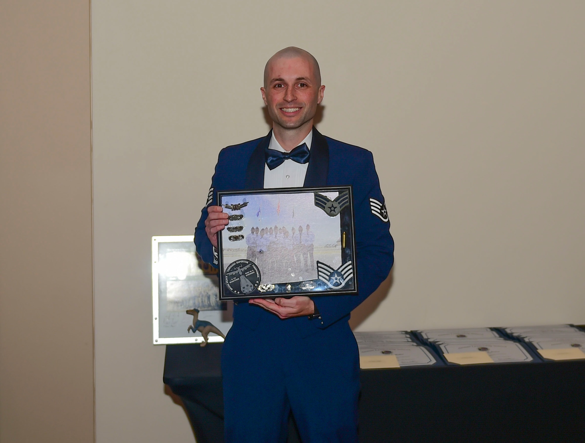 Staff Sgt. Daniel Johnson, 460th Force Support Squadron Airman Leadership School warthog flight instructor, receives a gift from the graduating class during their graduation Nov. 29, 2017, on Buckley Air Force Base, Colorado.