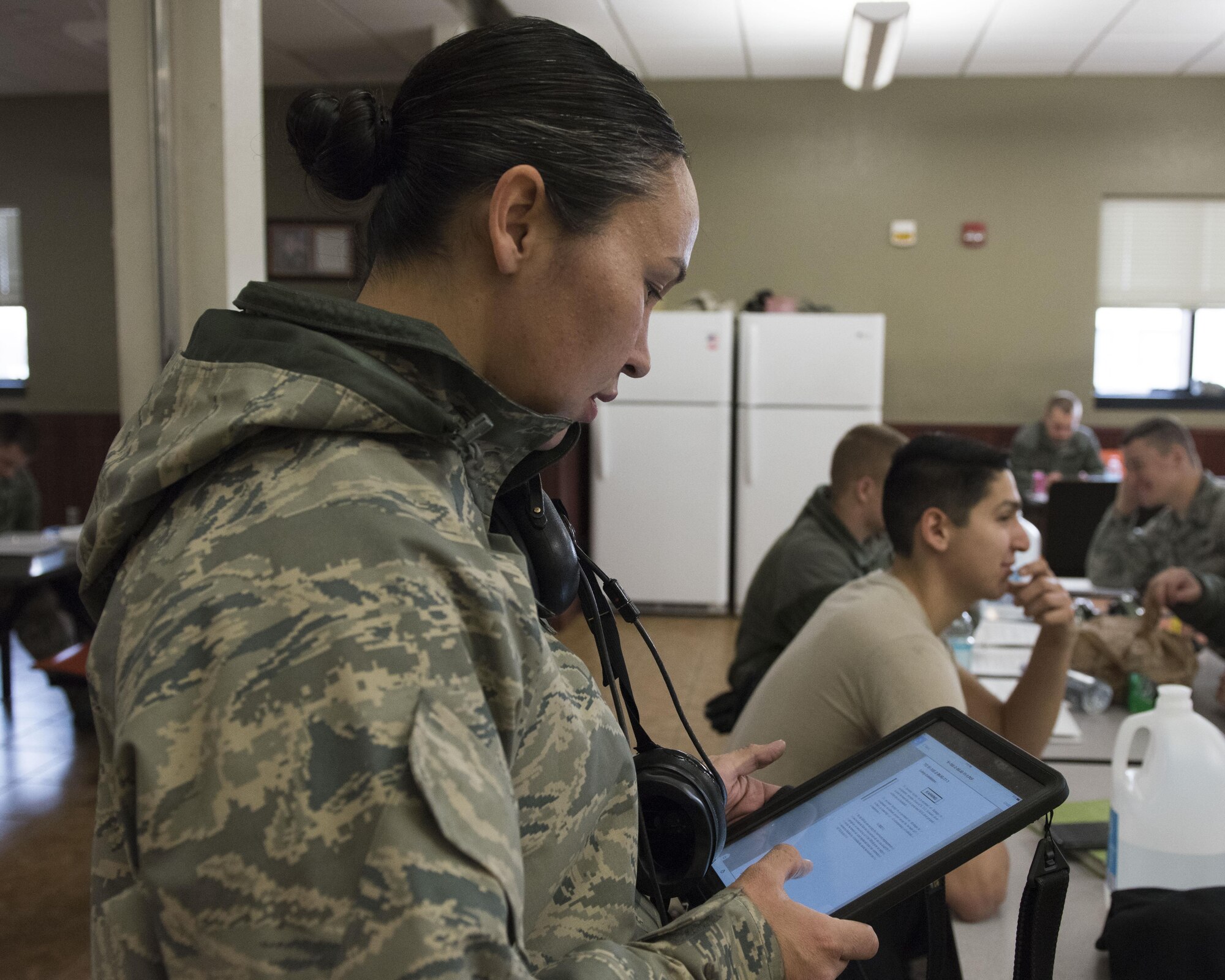 Image of Airman 1st Class Carol Russell, a 391st Aircraft Maintenance Unit F-15E avionics technician, glances over a technical order before heading out to help launch a jet Nov. 29, 2017, at Mountain Home Air Force Base, Idaho. Technical orders are manuals she can refer to when doing her job to ensure it's being done correctly.  (U.S. Air Force photo by Airman 1st Class Alaysia Berry)