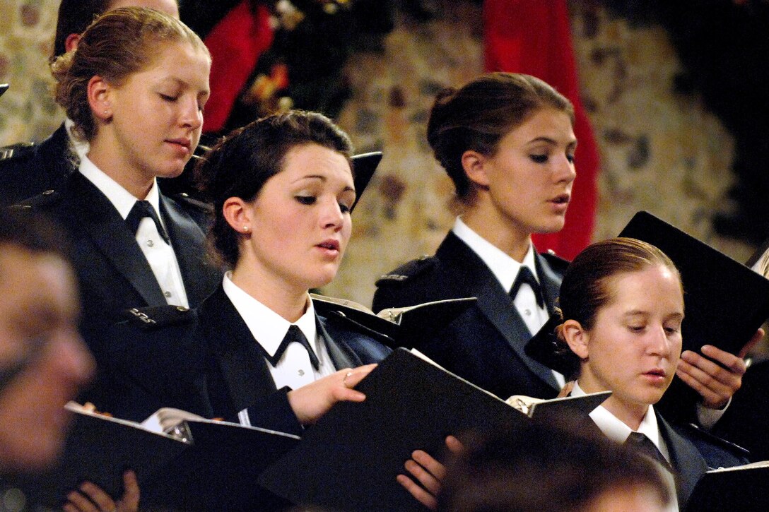 Cadets look at songbooks and sing.