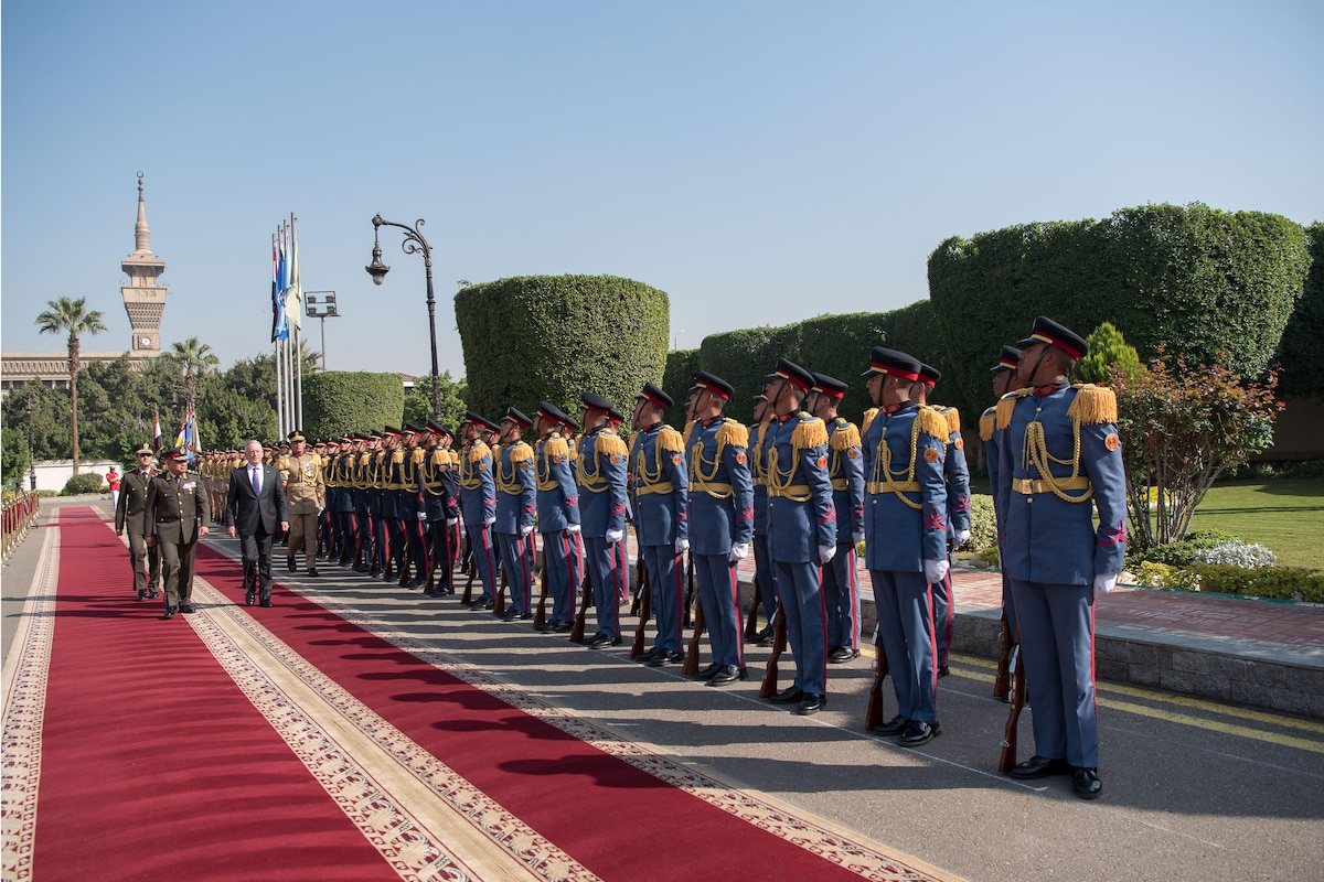 Defense Secretary James N. Mattis walks along a red carpet as he reviews Egyptian service members.