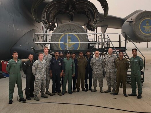 Propulsion specialists, Tech. Sgt. Jarrod Plotner and staff Sgt. Ben Wibmerly, third and fourth from right, pose for a photo with engine maintainers for the Indian Air Force, beside a C-17 Globmaster, a recent addition to the IAF. Plotner and Wimberly helped train their Indian counterparts on C-17 engine maintenance procedures in October and November.