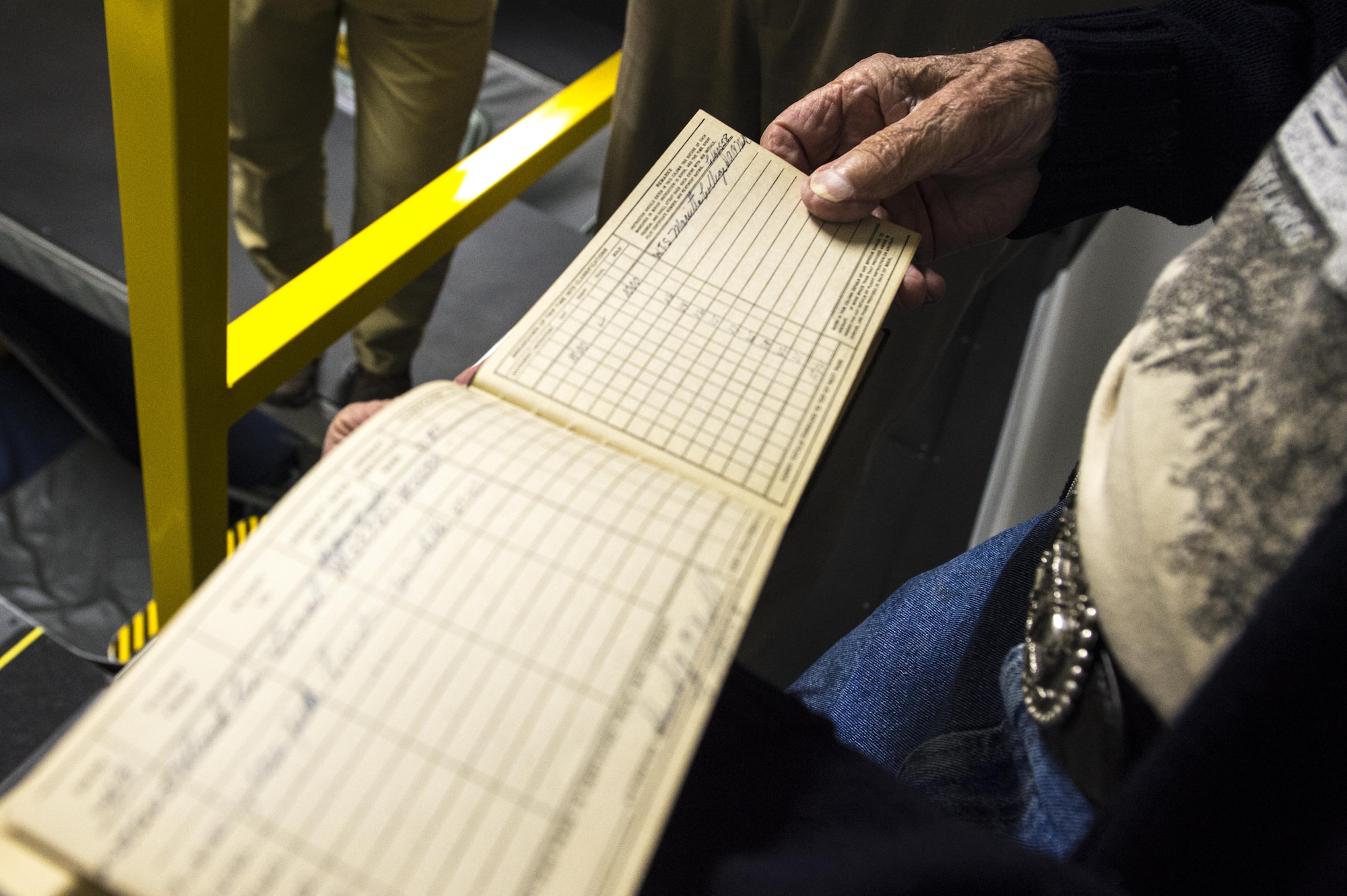 Robert Tobey shows a group of Airmen his flight log during a tour at Grissom Air Reserve Base, Ind., Oct. 27, 2017. Tobey, who piloted a B-17 Flying Fortress during World War II, was invited to tour Grissom and performed a simulated Stratotanker flight. (U.S. Air Force photo / Senior Airman Harrison Withrow)