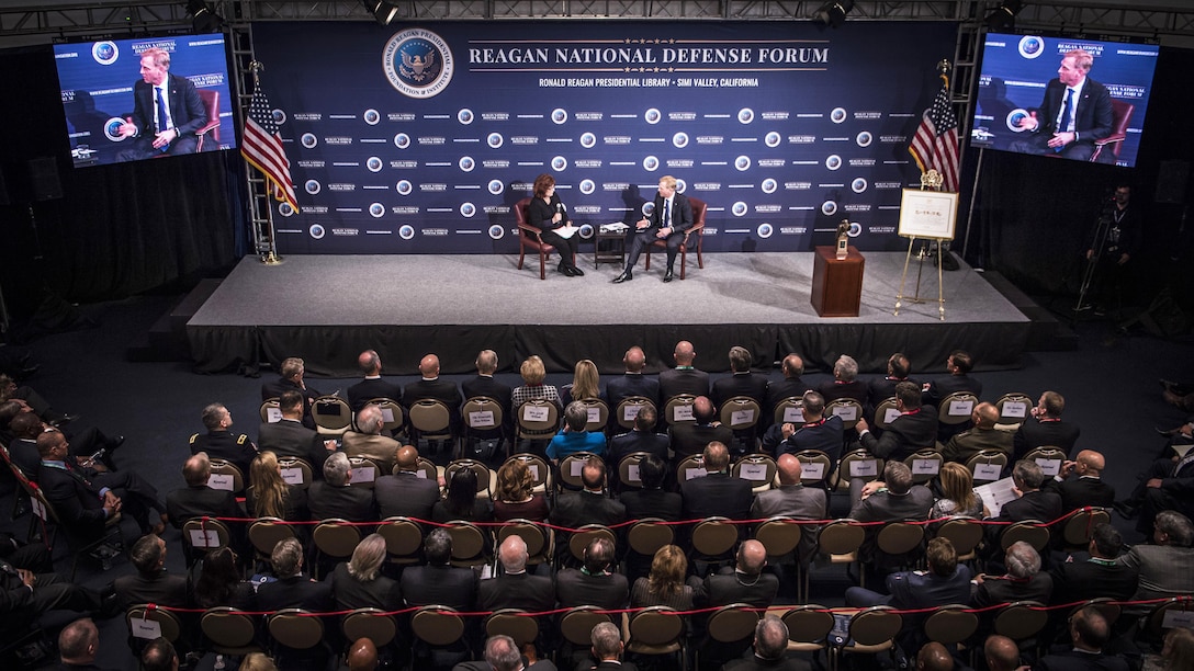 Deputy Defense Secretary Patrick M. Shanahan speaks with a reporter on a stage.