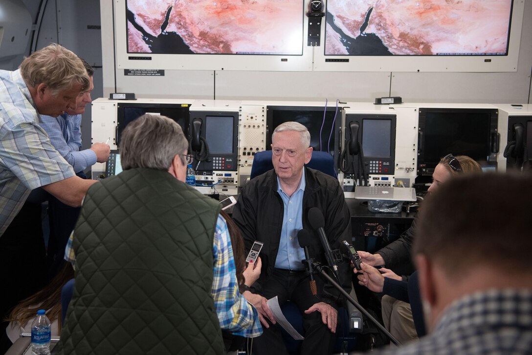 Defense Secretary James N. Mattis speaks with reporters aboard a plane.