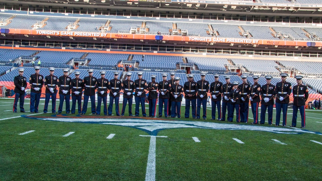Marines with Recruiting Station Denver pose on the Denver Broncos field before the Military Appreciation Game at the Sports Authority Stadium in Denver, CO, November 12, 2017.