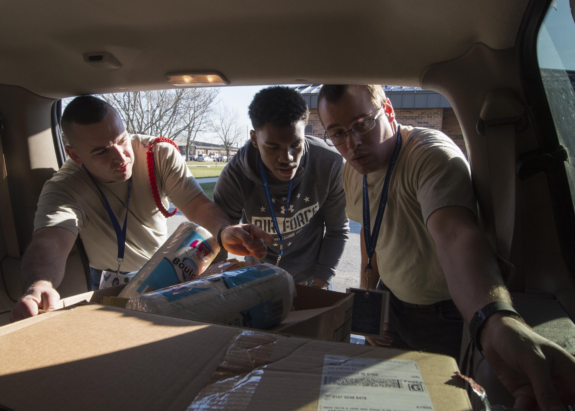 Joseph Brown, 434th Aircraft Maintenance Squadron D&TF trainee, Kenneth Blue, 434th AMXS D&TF trainee, and Liam Mellen, 434th Civil Engineer Squadron D&TF trainee, load donations into the car of one of the Angel Tree recipients at Grissom Air Reserve Base, Ind. on December 3, 2017. The Angel Tree program allows Grissom employees to help out their wingmen who are in need by donating food and gifts during the holiday season. (U.S. Air Force photo/Staff Sgt. Dakota Bergl)