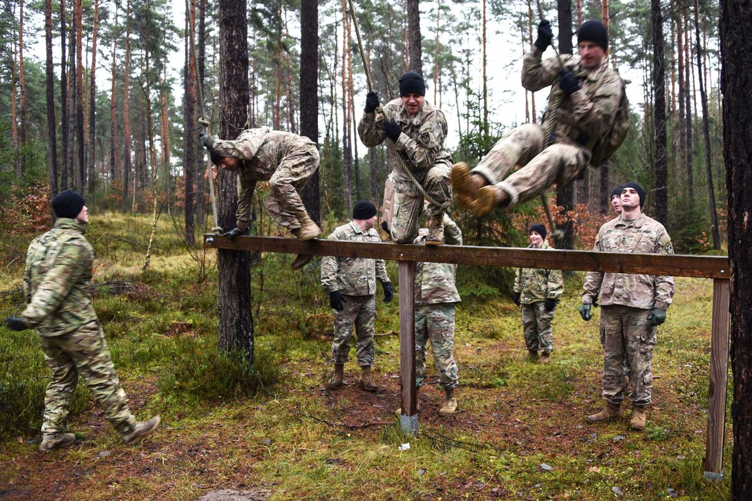 Soldiers use ropes to swing over an obstacle during the brigade’s first senior leader physical challenge.