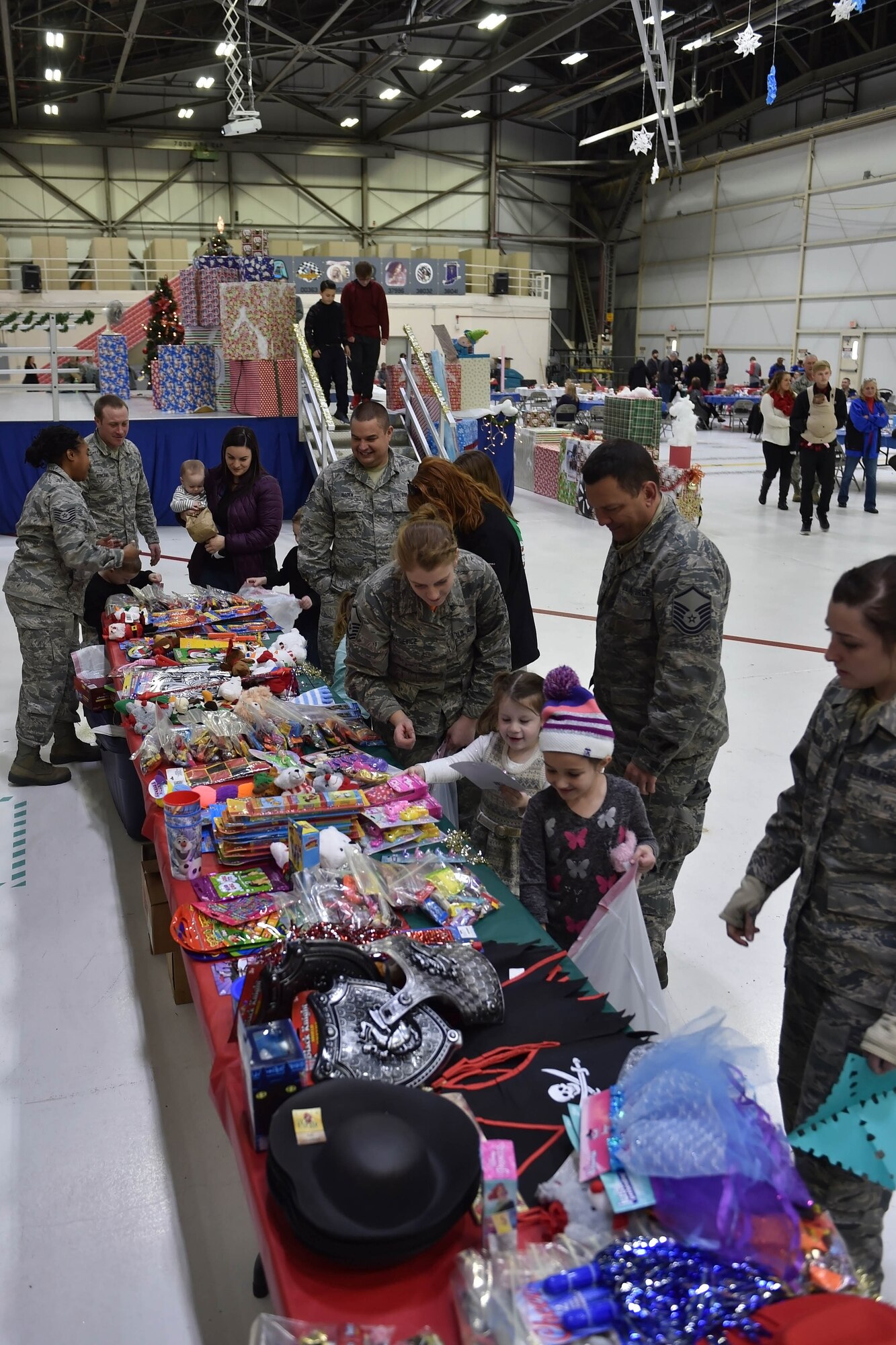 Airmen along with their little ones stuff their bags with toys of their choosing during a recent Christmas celebration. The celebration took place during Grissom’s Christmas childrens party here Dec. 2. (U.S. Air Force photo/Staff Sgt. Jami K. Lancette)