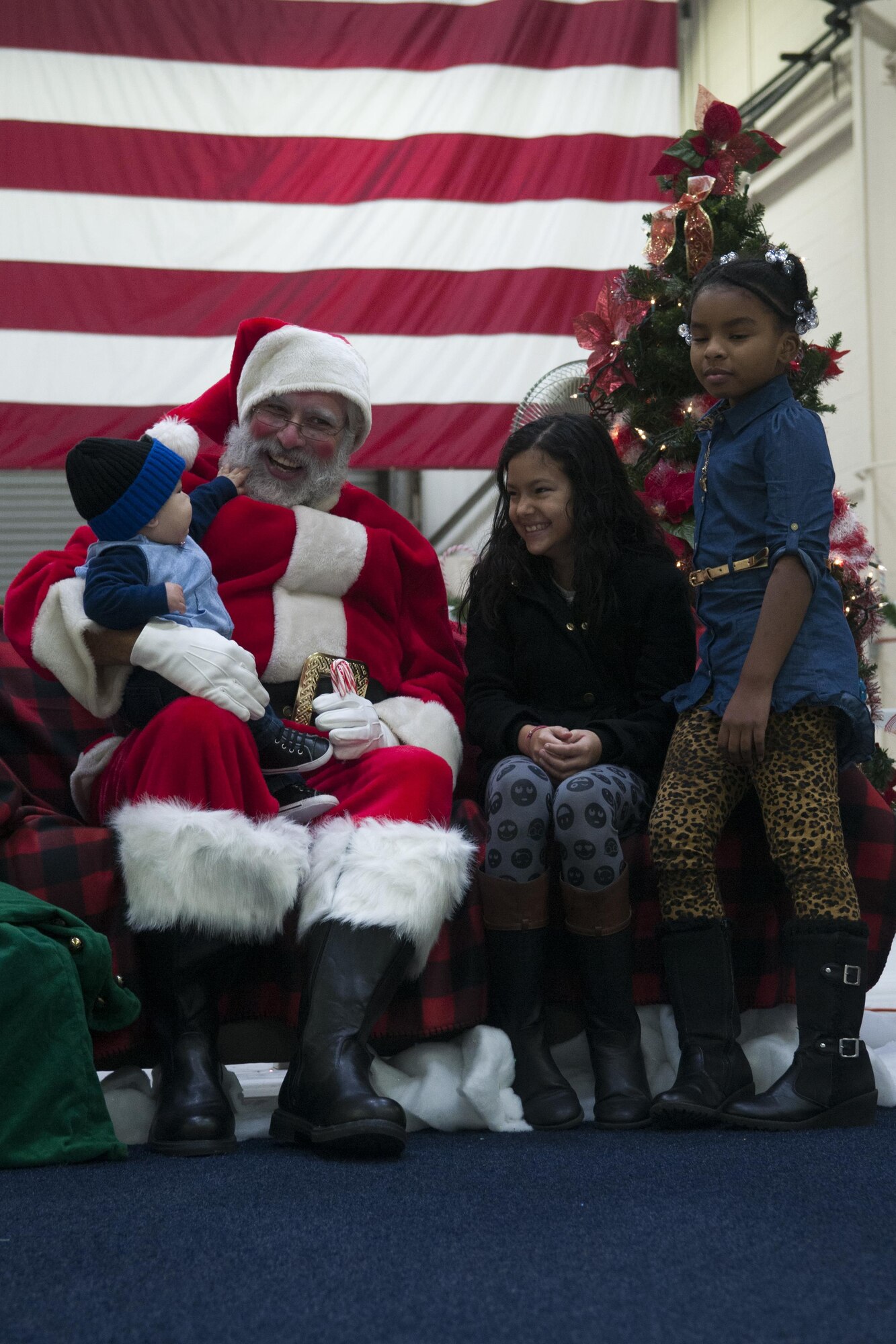 A young boy tugs on Santa's beard while his sister laugh during the annual Christmas party at Grissom Air Reserve Base, Ind. on Dec 2, 2017. Grissom's Christmas party is a chance for the families of Grissom members to come together and celebrate. (U.S. Air Force photo/Staff Sgt. Dakota Bergl)