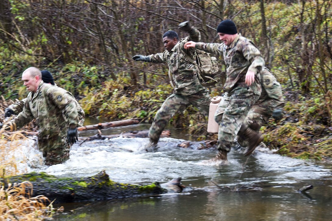 Soldiers across a creek during the brigade’s first senior leader physical challenge.