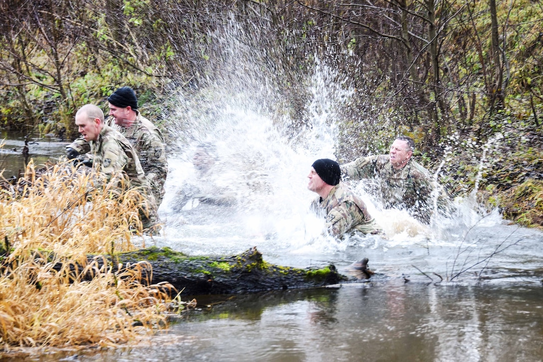 Soldiers jump into a creek during the brigade’s first senior leader physical challenge.
