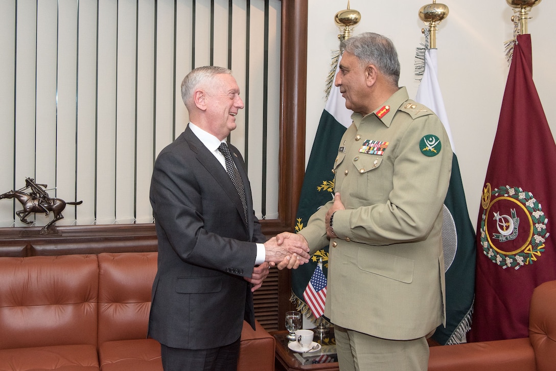Defense Secretary James N. Mattis shakes hands with a Pakistani general in a room.