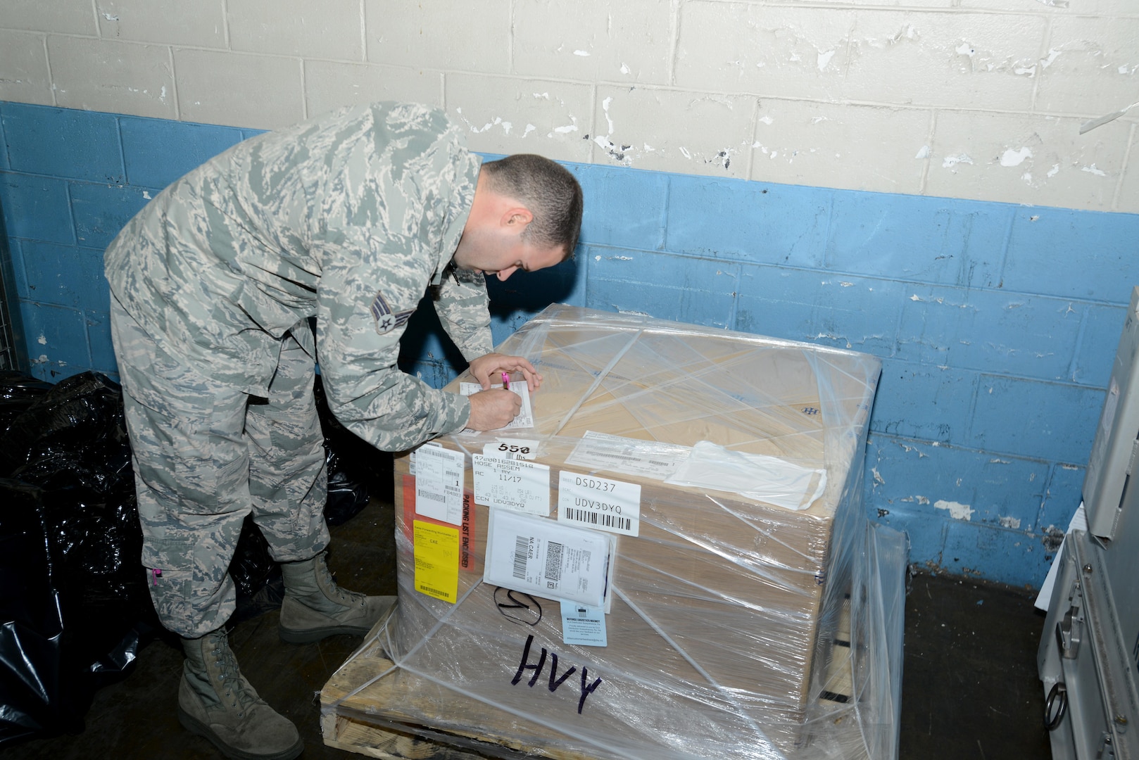 U.S. Air Force Senior Airman Adam Roberts, 20th Logistics Readiness Squadron (LRS) transportation management office inbound supervisor, signs a label for a package at Shaw Air Force Base, South Carolina, Nov. 29, 2017.