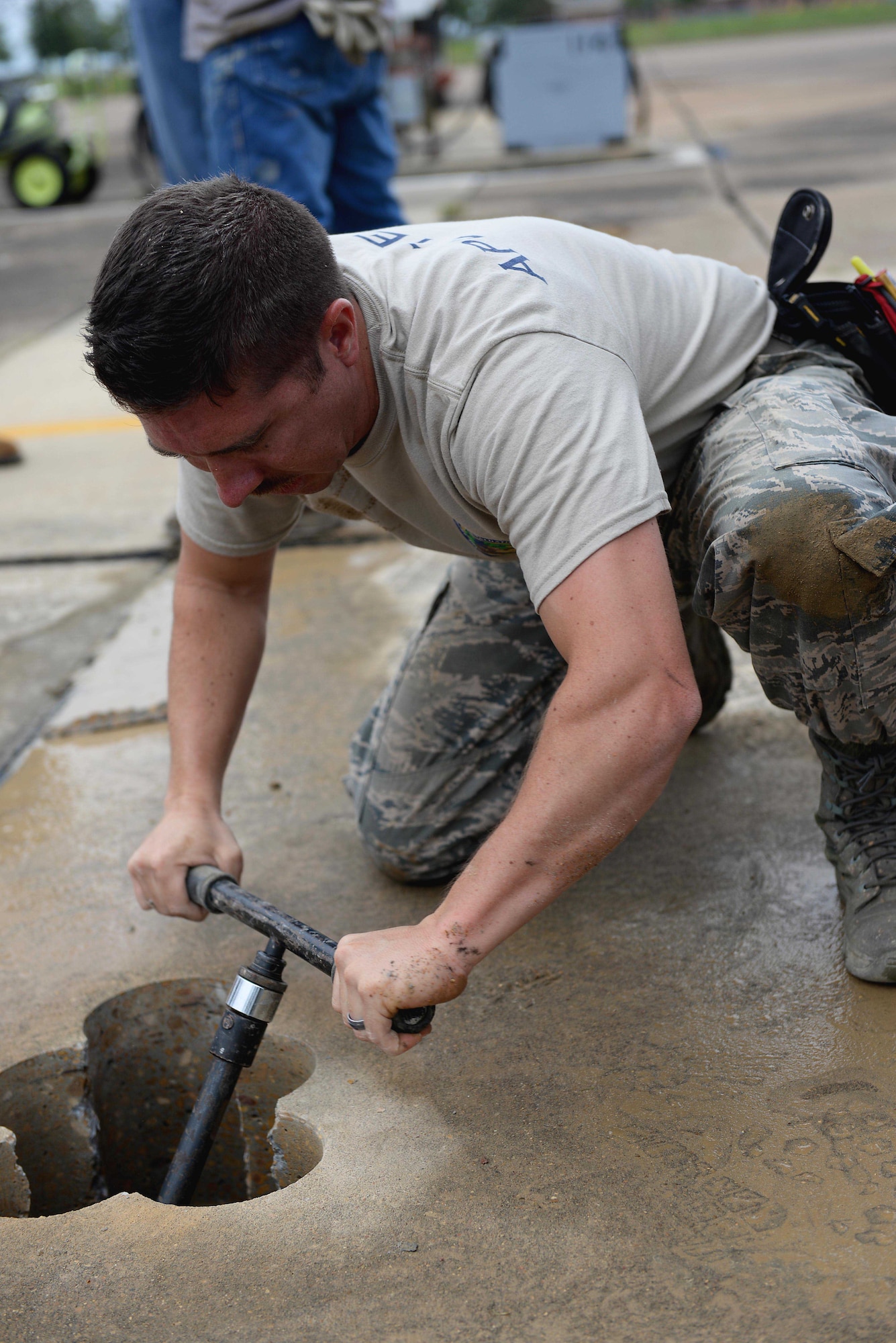 Capt. John Kulikowski, Air Force Civil Engineer Center APE Team Branch Chief, from Tyndall Air Force Base, Florida, inspects a hole on the airfield at Columbus Air Force Base, Mississippi, Oct. 11, 2017. A void under the T-1A Jayhawk parking ramp was determined to be roughly 50 feet in diameter and almost 4 feet deep, and was a result of water flowing underneath the concrete for many years, eroding the dirt below. (U.S. Air Force photo by Airman 1st Class Keith Holcomb)