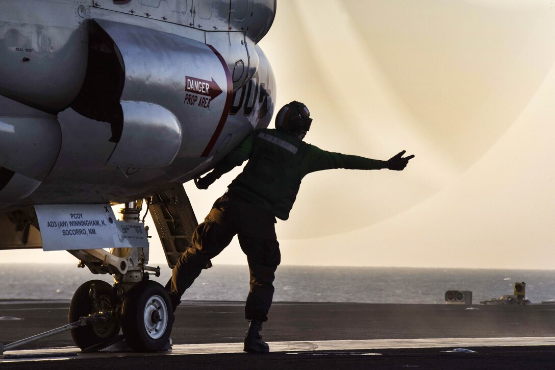 Navy Petty Officer 3rd Class Philip Powell readies an E-2C Hawkeye for launch.