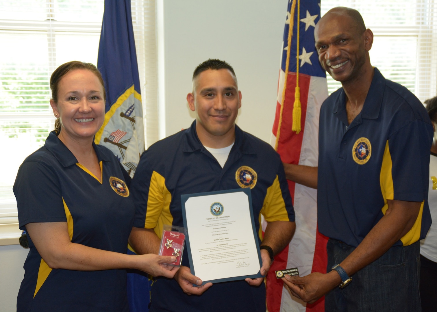 Former Commanding Officer Cmdr. Karen Muntean, Navy Recruiting District San Antonio and Command Master Chief Eric Mays stand with newly promoted Master-at-Arms 1st Class Christopher Thomas who was advanced to his current rank through the Navy’s Meritorious Advancement Program.